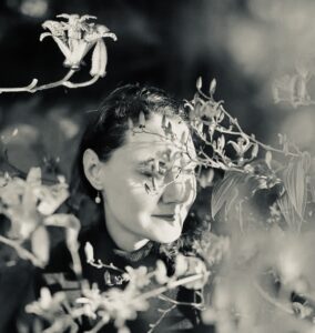 bahar behind branches with her eyes closed